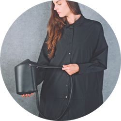 黒い衣装の女性モデルがシンプルな背景でバッグ商品を手に持つスタイリッシュなカット