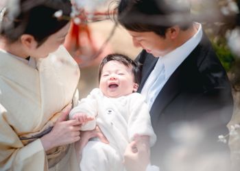 赤ちゃんを優しく抱く家族の温かい笑顔の写真