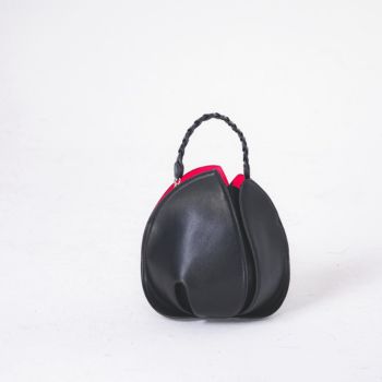 白背景の上に置かれた黒いハンドバッグのシンプルな商品写真